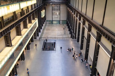 Londra'da Tate Modern Türbin Salonu'nun iç lerinde yürüyen insanlar
