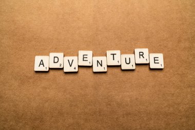 Londra, İngiltere - 24 Mayıs 2019: The Word Adventure, kahverengi dokulu arka plan üzerinde ahşap harf karoları ile yazılmış