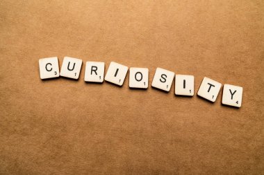 Londra, İngiltere - 24 Mayıs 2019: Kelime Curiosity, kahverengi dokulu arka plan üzerinde ahşap harf karoları ile yazılmış