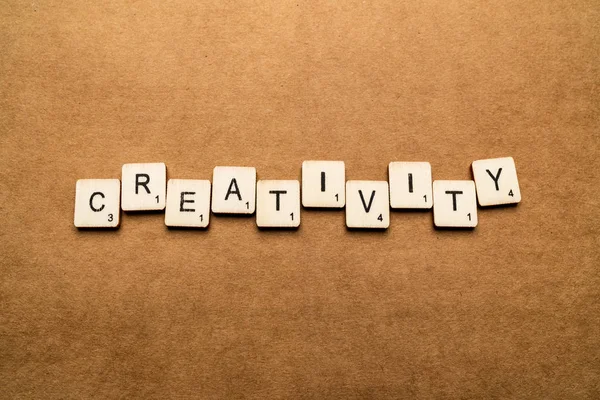 London, uk - 24. Mai 2019: das Wort Kreativität, geschrieben mit Buchstabenkacheln aus Holz vor braunem strukturiertem Hintergrund — Stockfoto