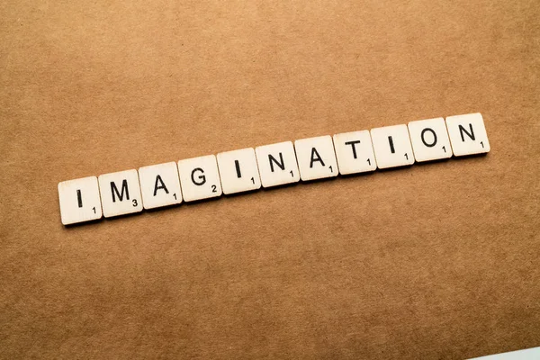 LONDRES, Reino Unido - 24 de maio de 2019: A palavra IMAGINAÇÃO, escrita com letras de madeira sobre um fundo castanho texturizado — Fotografia de Stock