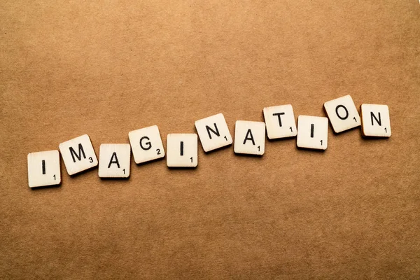 LONDRES, Reino Unido - 24 de maio de 2019: A palavra IMAGINAÇÃO, escrita com letras de madeira sobre um fundo castanho texturizado — Fotografia de Stock