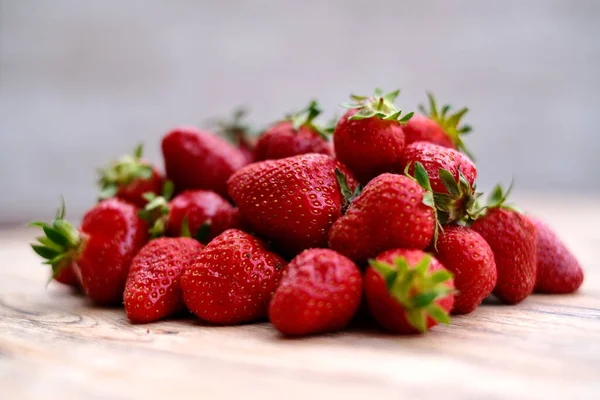  Tahta bir masanın üstünde kırmızı aromalı sulu çilek.