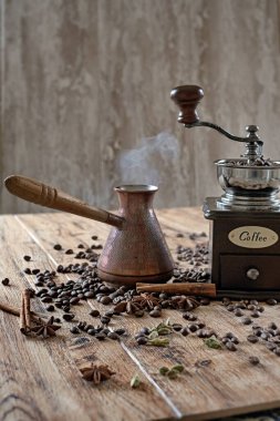  Kahve çekirdekleri ve baharatlarla ahşap masada eski moda el değirmeni. 