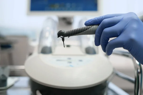 Dentistas mano en guantes azules trabajando con pieza de mano l en oficio dental — Foto de Stock