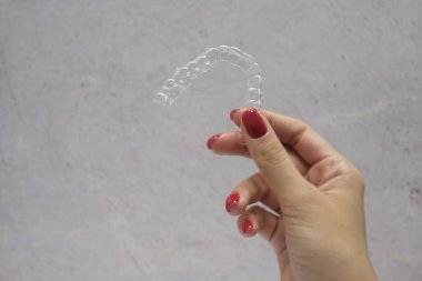 Gri arkaplan üzerinde kadınların diş hizalama yakın çekim