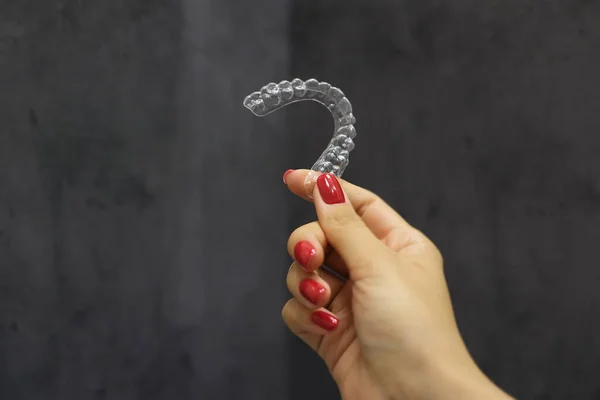 Gri arkaplan üzerinde kadınların diş hizalama yakın çekim