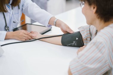 Doktor, yaşlı hastanın kan basıncını ölçüyor. Sağlık hizmetleri.