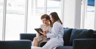 Genç doktor, sağlık kliniğindeki kıdemli hastaya danışmanlık yapıyor.