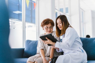 Genç doktor, sağlık kliniğindeki kıdemli hastaya danışmanlık yapıyor.