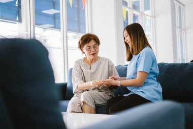 Genç doktor, sağlık kliniğindeki kıdemli hastaya danışmanlık yapıyor.