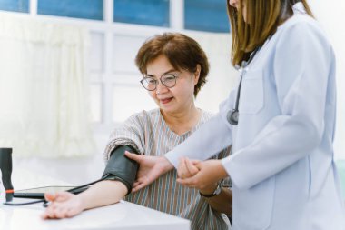 Doktor, yaşlı hastanın kan basıncını ölçüyor. Sağlık hizmetleri.