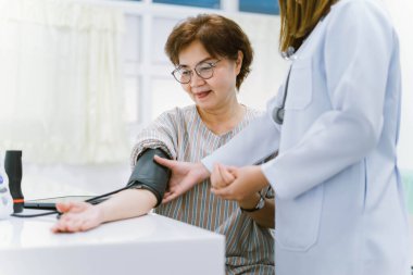 Doktor, yaşlı hastanın kan basıncını ölçüyor. Sağlık hizmetleri.