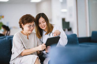 Genç doktor, sağlık kliniğindeki kıdemli hastaya danışmanlık yapıyor.