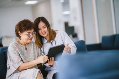 Genç doktor, sağlık kliniğindeki kıdemli hastaya danışmanlık yapıyor.