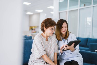Genç doktor, sağlık kliniğindeki kıdemli hastaya danışmanlık yapıyor.
