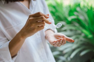 Kadın elini temizlemek için alkol antiseptik jel kullanıyor.