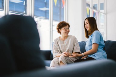 Genç doktor, sağlık kliniğindeki kıdemli hastaya danışmanlık yapıyor.