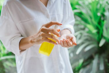 Kadın elini temizlemek için alkol antiseptik jel kullanıyor.