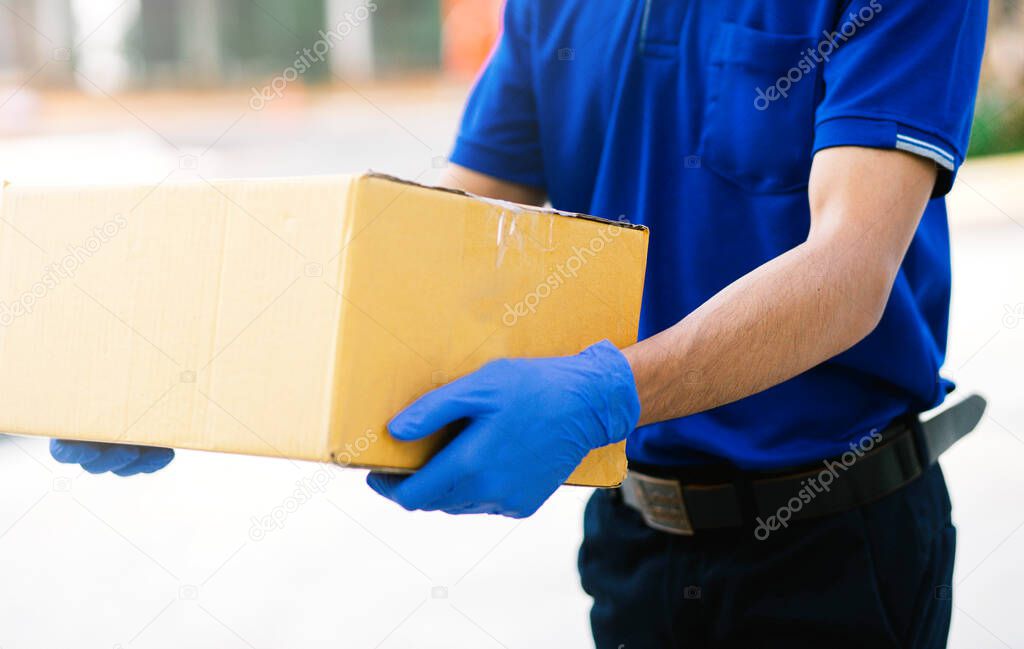 Delivery man put on gloves and masks to hold cardboard boxes