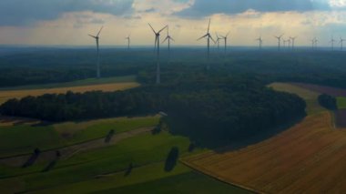 Almanya 'daki Berlichingen yakınlarındaki rüzgar türbinlerinin hava görüntüsü. Baharın ilerleyen saatlerinde bulutlu bir gökyüzüyle.