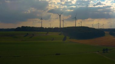 Almanya 'daki Berlichingen yakınlarındaki rüzgar türbinlerinin hava görüntüsü. Baharın ilerleyen saatlerinde bulutlu bir gökyüzüyle.