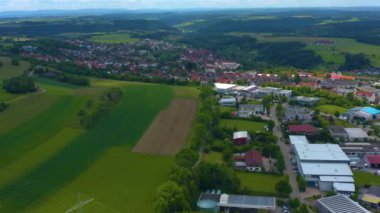 Almanya 'daki Hallwangen' in hava görüntüsü. Kamera tarlalardan sola, arka planda başka bir kasaba olan küçük bir kasabaya doğru dönüyor..