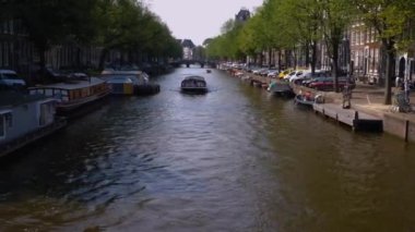 Hollanda, Amsterdam 'da bir kanalda seyahat eden tekne.
