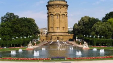 Yazın güneşli bir günde Almanya 'nın Mannheim kentindeki Friedrichsplatz' da su kulesi ve çeşme manzarası.