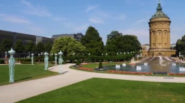 Yazın güneşli bir günde Almanya 'nın Mannheim kentindeki Friedrichsplatz' da su kulesi ve çeşme manzarası.