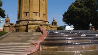 Yazın güneşli bir günde Almanya 'nın Mannheim kentindeki Friedrichsplatz' da su kulesi ve çeşme manzarası.