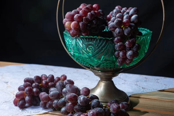 grapes on a table with an old fruit bowl