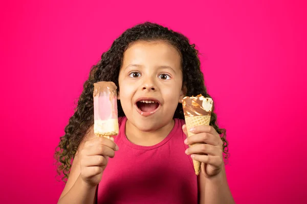 Happy child with two ice creams in hand with lilac background, selective focus.