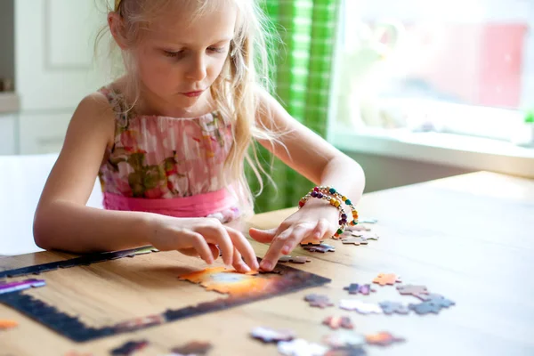 Baba ve kızı bulmacayı masada otururken bir araya getiriyorlar. Yağmur, kötü hava ve karantina sırasındaki oyunlar. Evde aile içi rahatlatıcı eğitim oyunları.