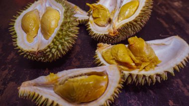 Durian aşıkları için olgun Durian spesiyali, ahşap arka planda yemeye hazır. Durian meyvelerin kralı olarak bilinir. Kokuyor ve kabuğu dikenlerle kaplı.