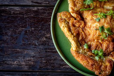 Tahta masadaki bir tabakta omlet.