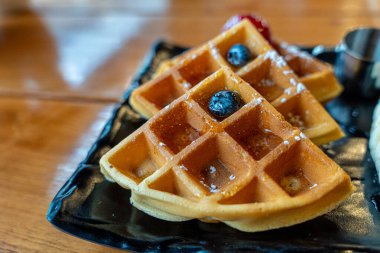 Bal şuruplu leziz waffle 'lar ve kafede taze meyveler.
