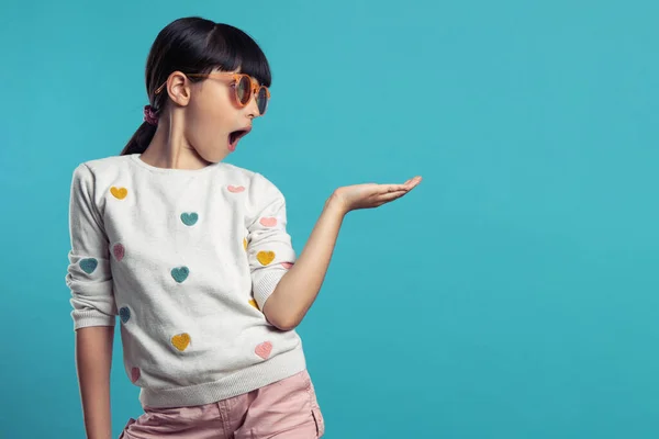 Profildeki sevimli kız mavi arka planda güneş gözlüğü takıyor.