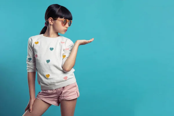 Profildeki güzel kız mavi arka planda güneş gözlüğü takıyor.