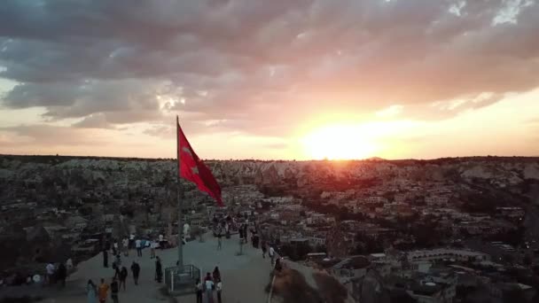 Widok z lotu ptaka na zachód słońca nad Kapadocją. Flaga turecka na widoku nad krajobrazem — Wideo stockowe