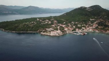 Lopud Adası, Hırvatistan. Kıyı şeridinin, manastırın, kilisenin ve teknelerin havadan görünüşü