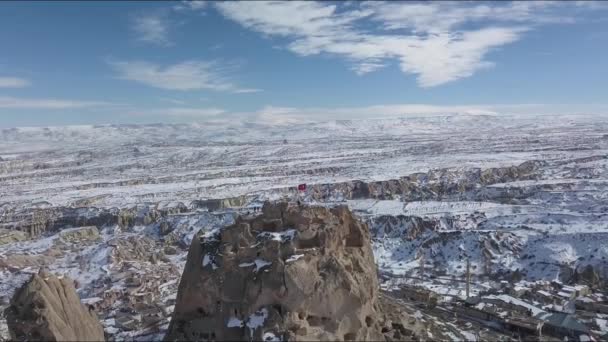 Vista aérea da bandeira turca na formação rochosa acima da cidade de Uchisar, Capadócia — Vídeo de Stock