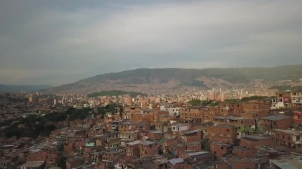 コロンビアのメデリンの航空写真。都市景観とコミューンツリースラムの上を飛ぶ — ストック動画