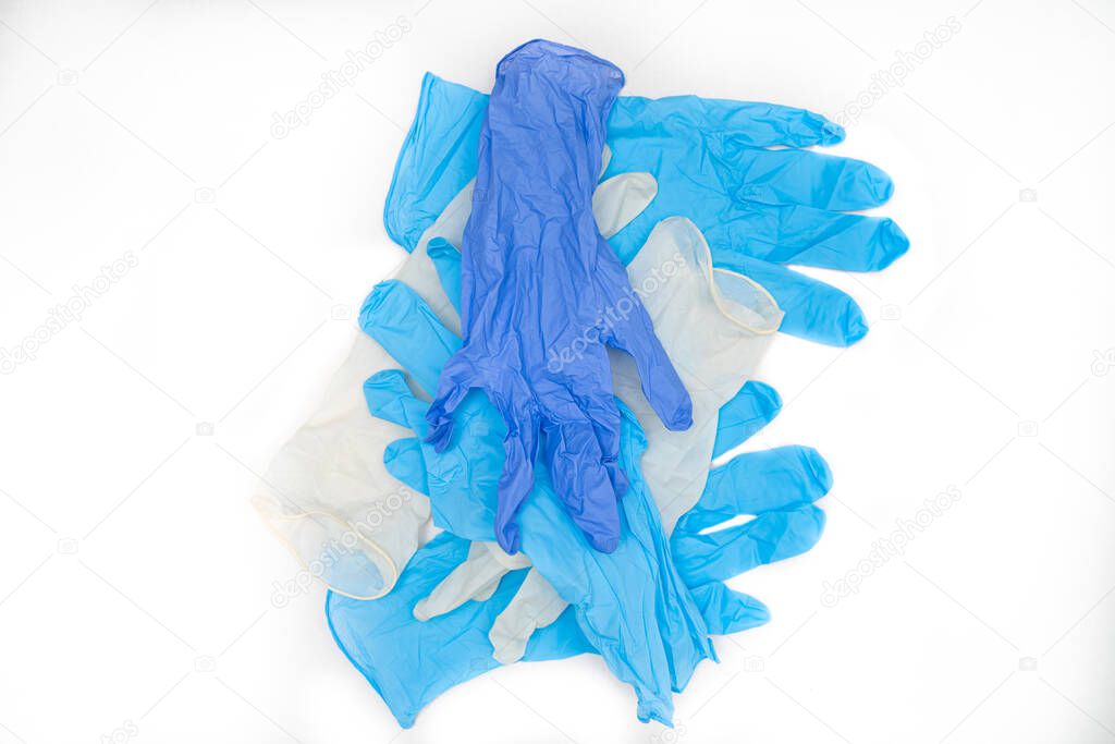 many protective disposable latex gloves lying on a white background