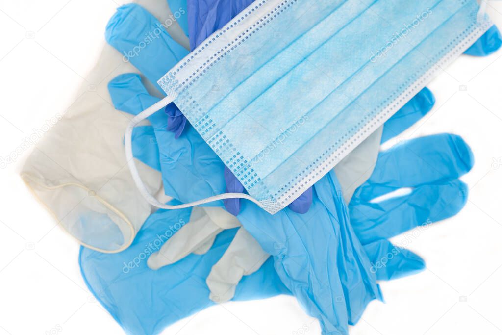 protective mask and disposable latex gloves lying on a white background
