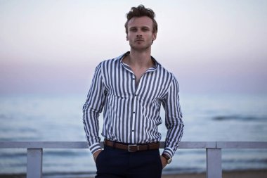 günbatımı okyanus üzerinde genç çekici adamla tanışıyor. Moda stil tatil kavramı