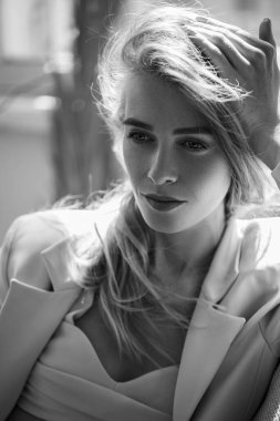 Kameraya gülümseyen çilli, şık kızıl kızın portresi. Modaya uygun kıyafetlerin reklam fotoğrafını çekme fikri. Etnik arka plan, sıra dışı bitki yaprakları