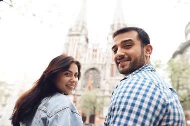 Romantik çift şehirde el ele dolaşıyor. Geri görünüm.