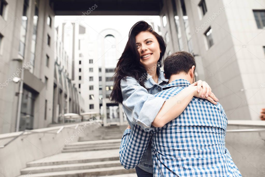 Love story. Guy in plaid shirt hugs girl. Romantic couple.