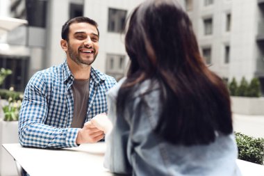 Kafede masada oturan mutlu bir çift. Adam kıza gülümsüyor. Romantik kavram